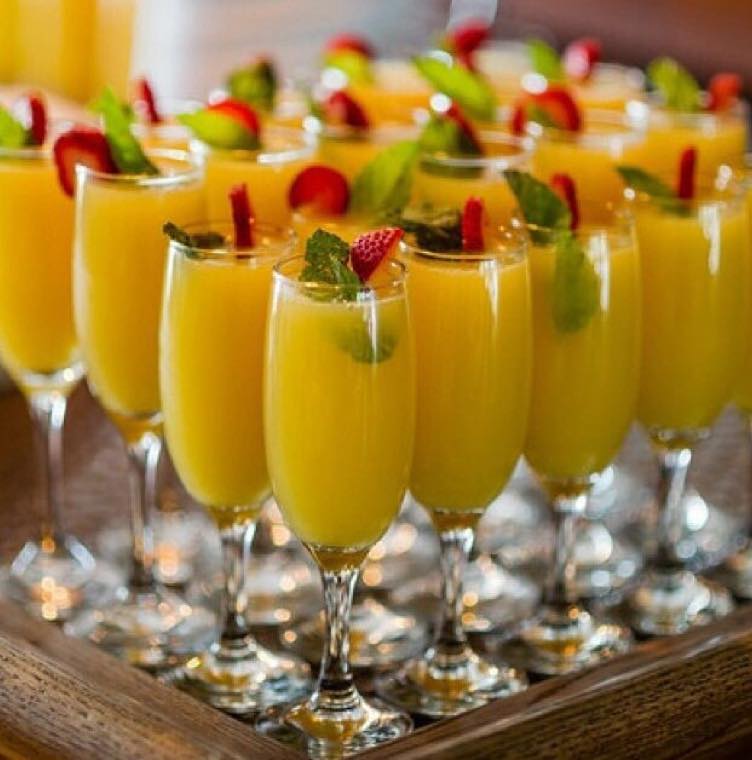 Rangée de cocktails maison aux fruits frais, décorés de menthe et de fraise