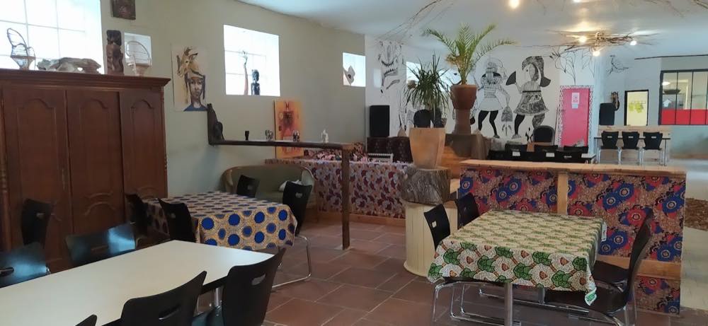 La salle du restaurant, nappes en tissu wax et décoration ivoirienne
